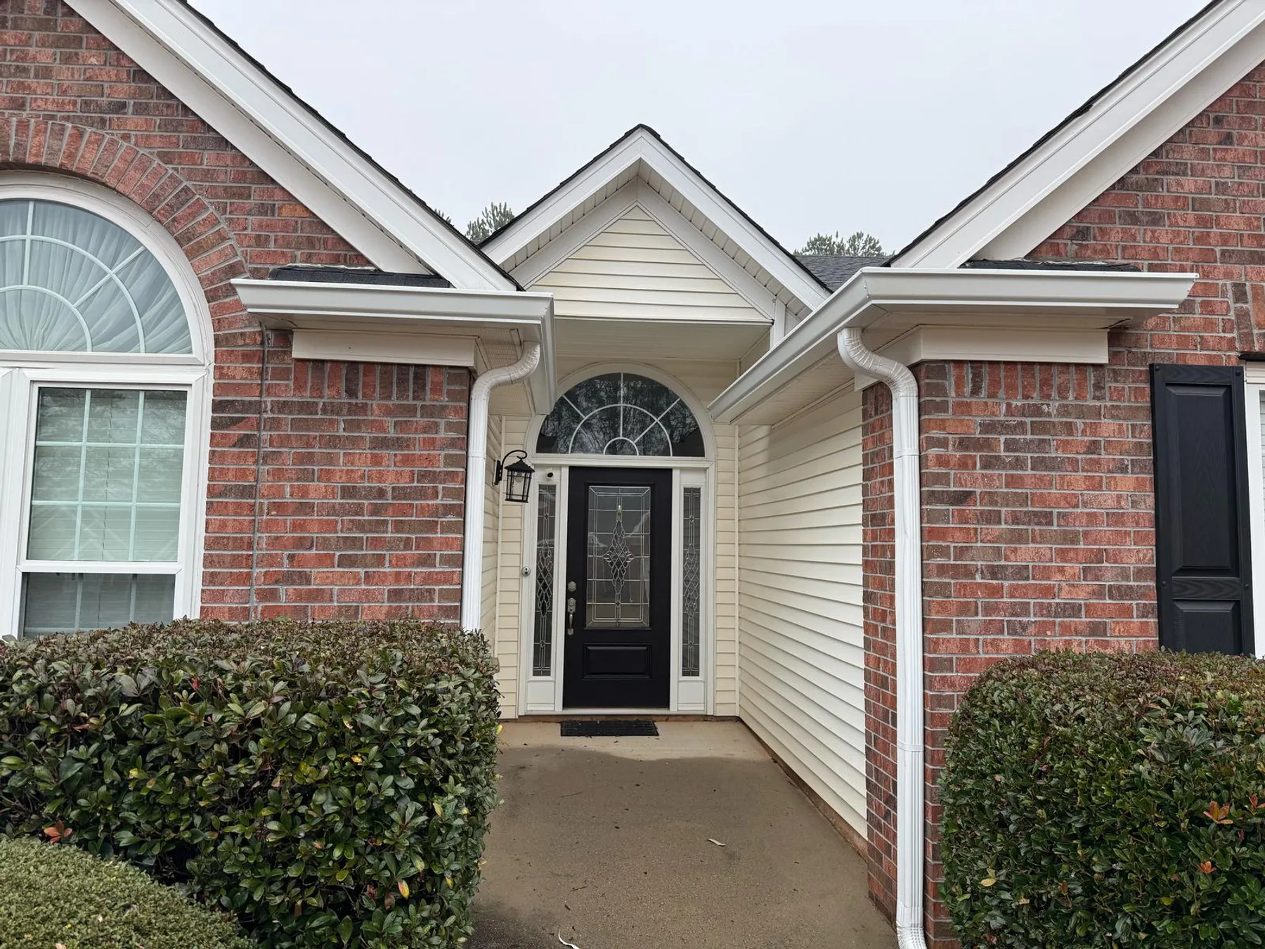 Finished gutter installation on a brick home entrance