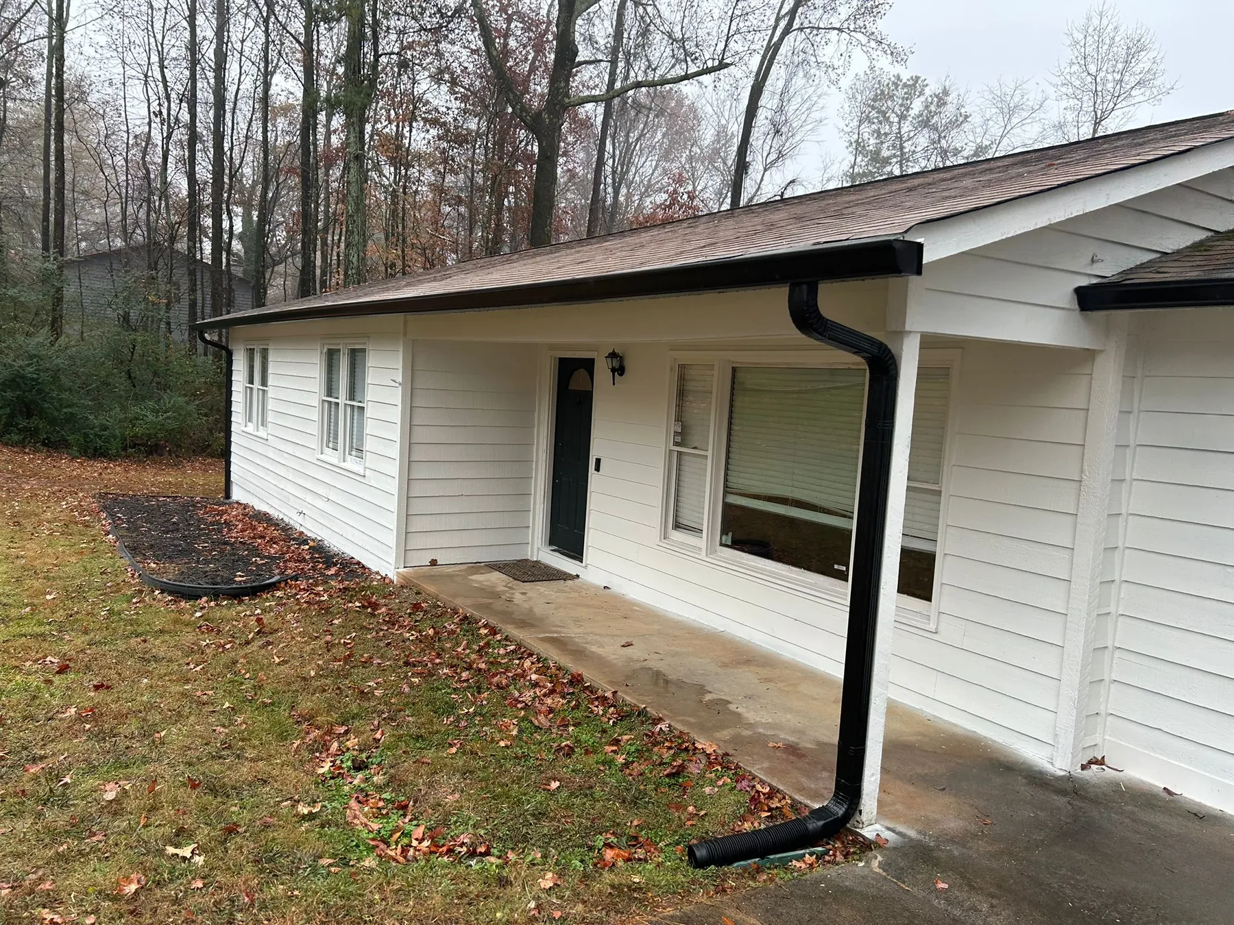Finished gutter installation on a white ranch-style home
