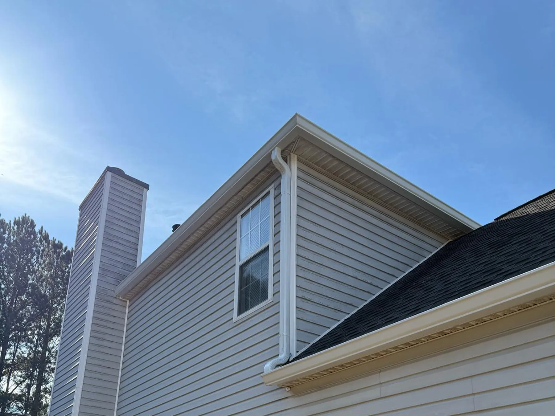 Completed gutter and downspout installation on a brick home